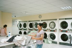 photo of woman standing inside the laundromat 2927523